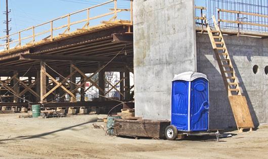 a row of sturdy portable restrooms at a construction site